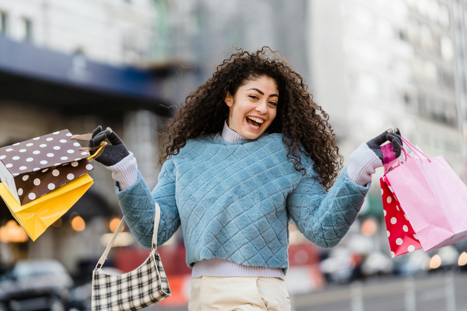 A cheerful woman with shopping bags enjoying a day out in the city.